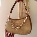 the Coach Teri Shoulder Bag. The specific version shown is crafted from straw and refined pebble leather