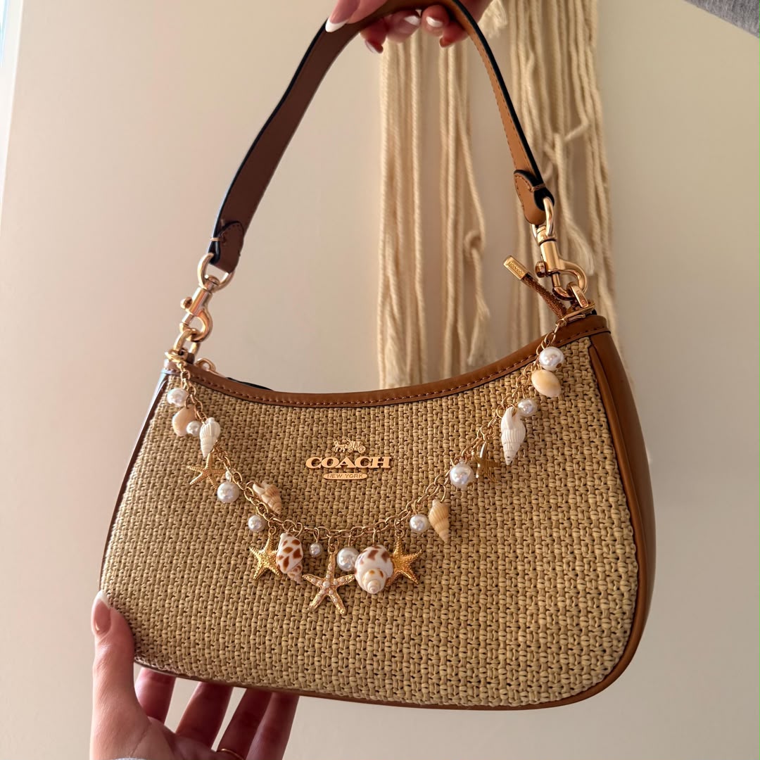 the Coach Teri Shoulder Bag. The specific version shown is crafted from straw and refined pebble leather